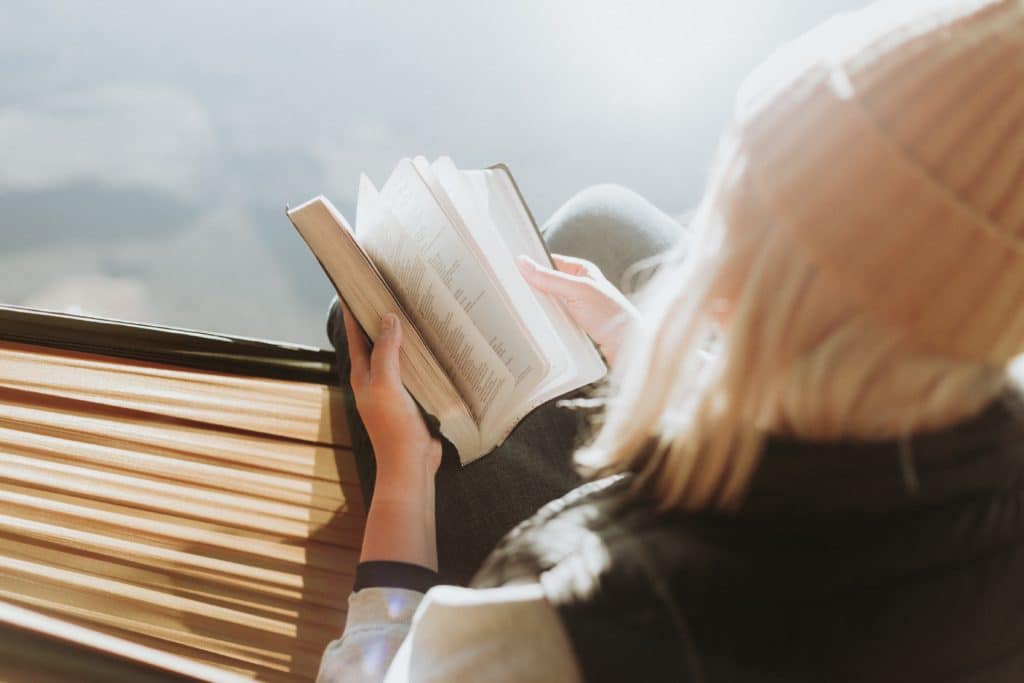 girl in hammock reading Bible Verses about camping