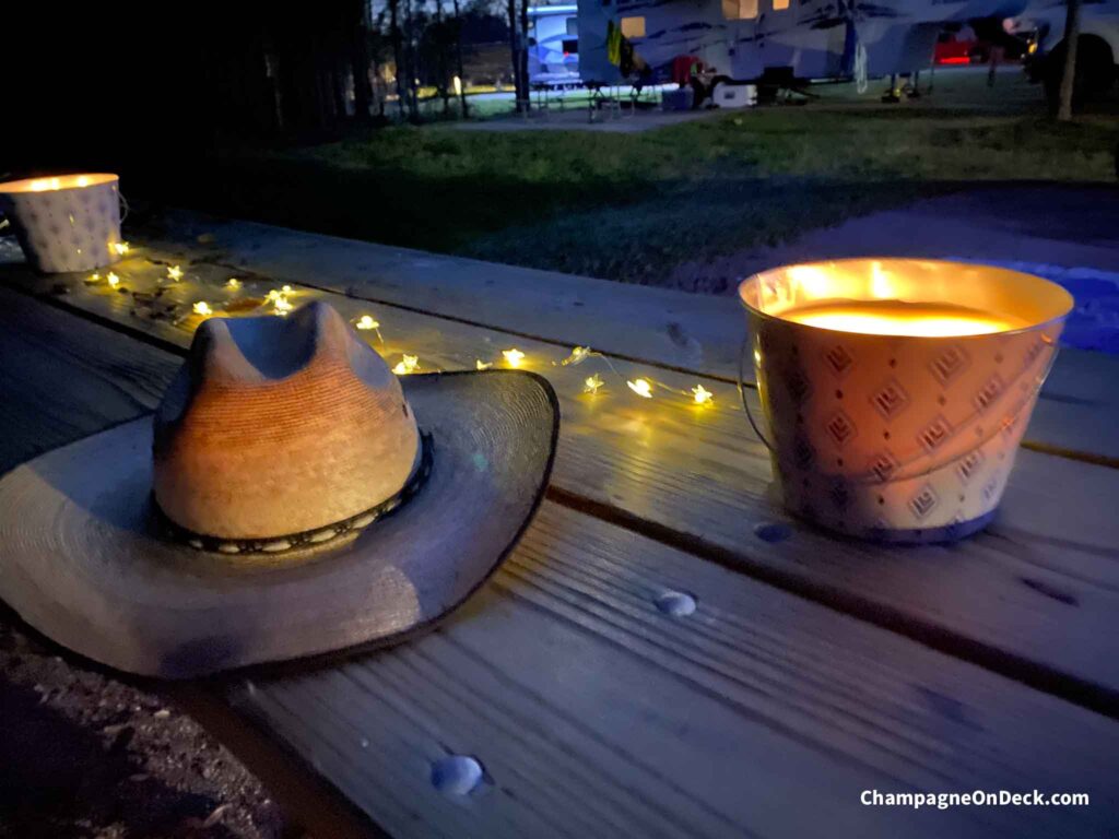 Hat on picnic table with citronella candle